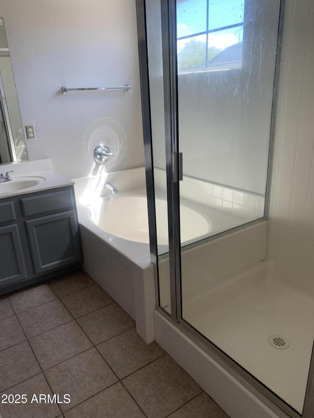 full bathroom featuring a shower stall, a garden tub, vanity, and tile patterned floors