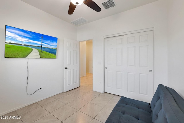 bedroom featuring ceiling fan, light tile patterned flooring, and a closet