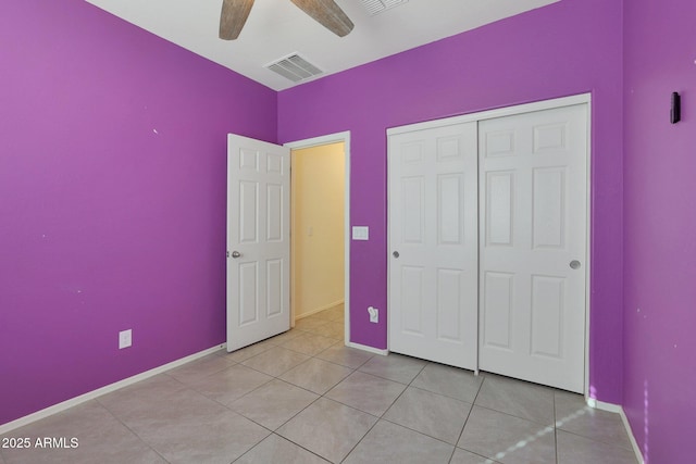 unfurnished bedroom with ceiling fan, light tile patterned flooring, and a closet