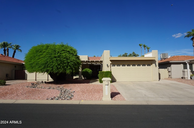 view of front of property featuring central AC and a garage