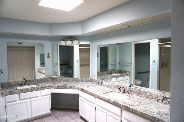 bathroom with tile patterned flooring, vanity, toilet, and an enclosed shower