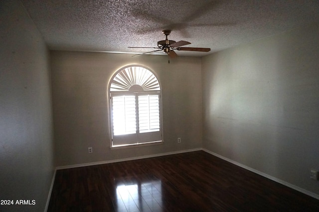 spare room featuring a textured ceiling, ceiling fan, and dark wood-type flooring