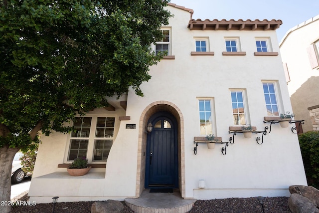 entrance to property with stucco siding and a tile roof