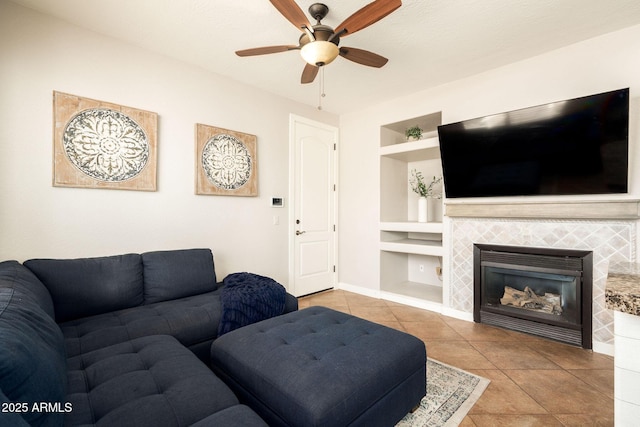 tiled living room featuring built in features, a tile fireplace, and ceiling fan