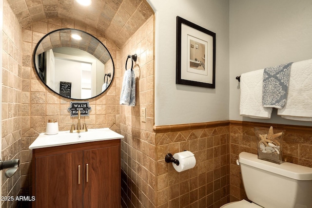 bathroom with vanity, tile walls, and toilet