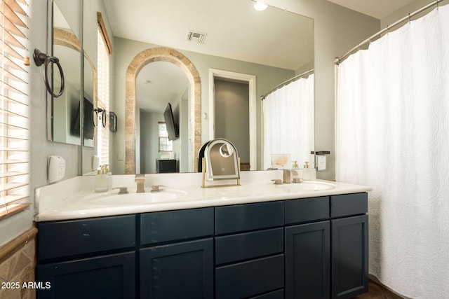 bathroom featuring a sink, visible vents, and double vanity