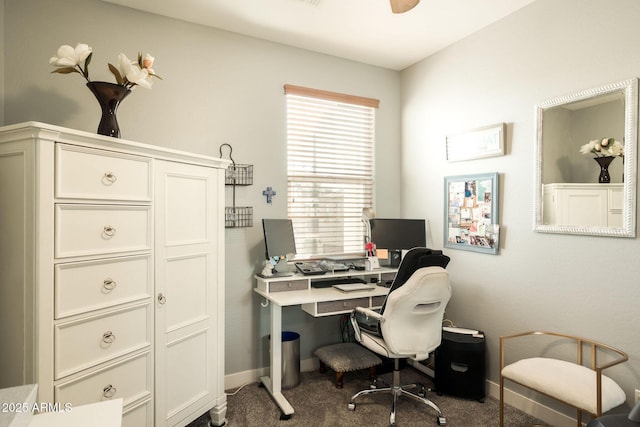 carpeted office space featuring baseboards and ceiling fan