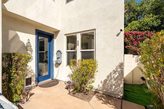 doorway to property with stucco siding and a patio