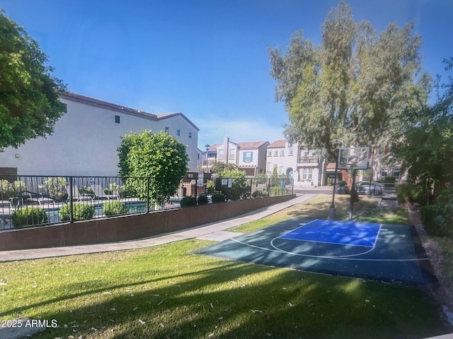 view of sport court featuring a residential view, community basketball court, a yard, and fence