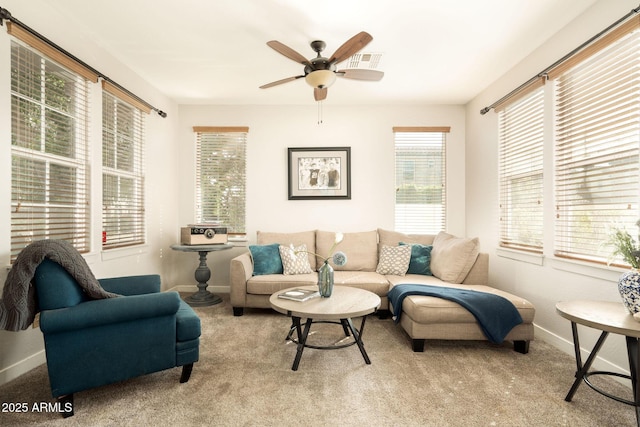 carpeted living room with baseboards, visible vents, and ceiling fan