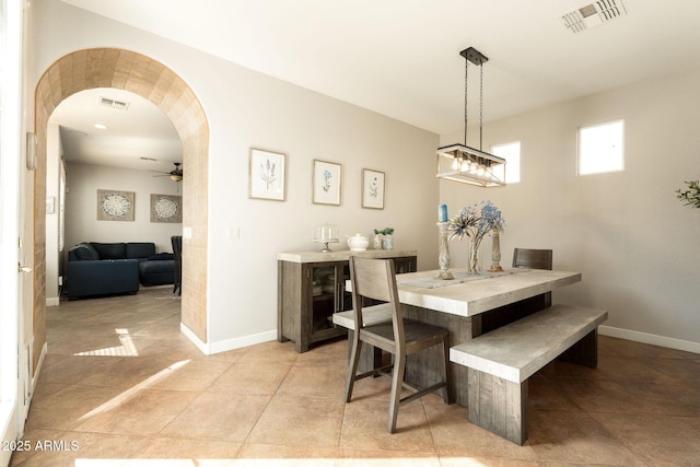 dining area with arched walkways, visible vents, and baseboards