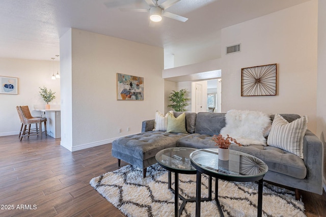 living room with dark wood-type flooring and ceiling fan