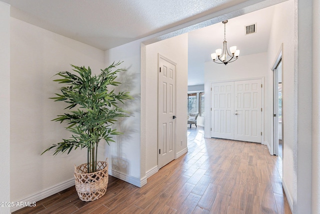 foyer with hardwood / wood-style floors and an inviting chandelier