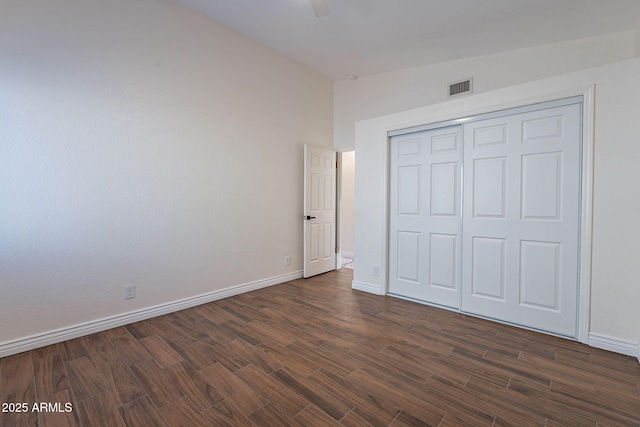 unfurnished bedroom featuring a closet, vaulted ceiling, dark hardwood / wood-style floors, and ceiling fan