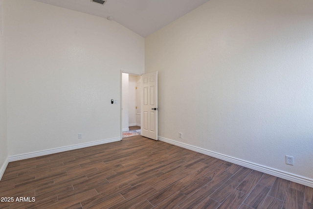 unfurnished room featuring dark wood-type flooring and high vaulted ceiling