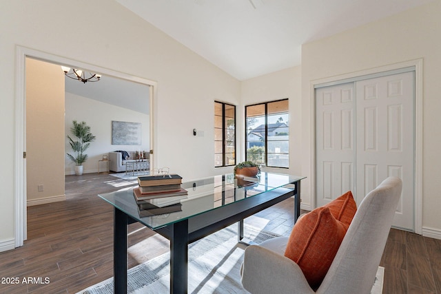 office space featuring lofted ceiling, dark wood-type flooring, and an inviting chandelier