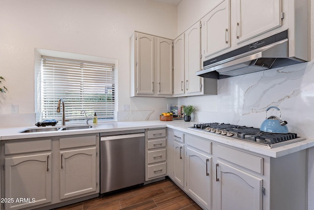 kitchen with appliances with stainless steel finishes, tasteful backsplash, white cabinetry, sink, and dark wood-type flooring