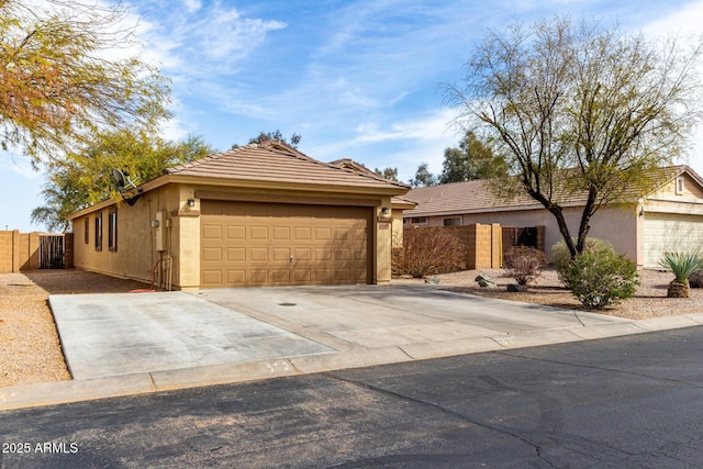 view of front facade featuring driveway, a tile roof, fence, and stucco siding