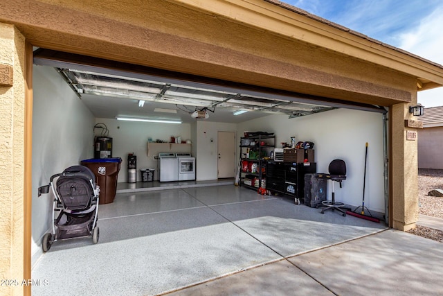 garage with a garage door opener, water heater, and washer and clothes dryer