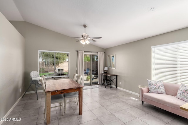 dining room with a ceiling fan, light tile patterned flooring, vaulted ceiling, and baseboards