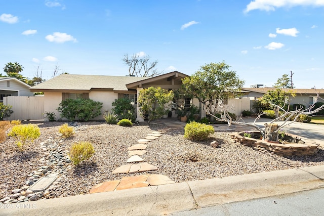 view of front of house with fence and stucco siding