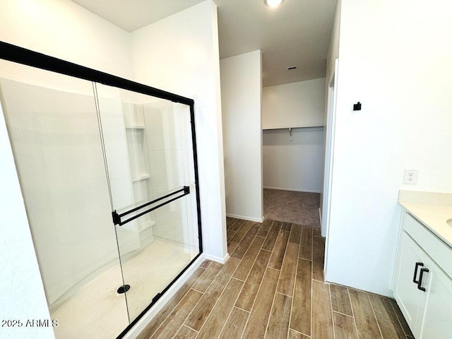 bathroom featuring vanity and a shower with door