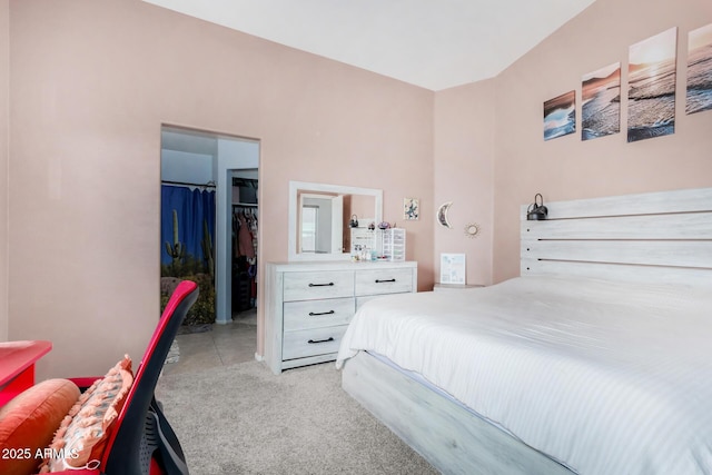 bedroom with light carpet, a closet, and a walk in closet