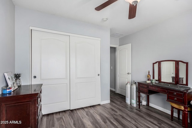 bedroom featuring wood finished floors, a ceiling fan, visible vents, baseboards, and a closet