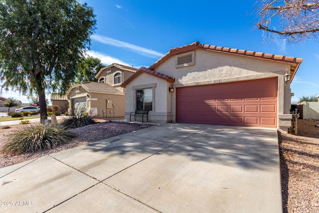 mediterranean / spanish-style home with a garage, driveway, a tile roof, and stucco siding