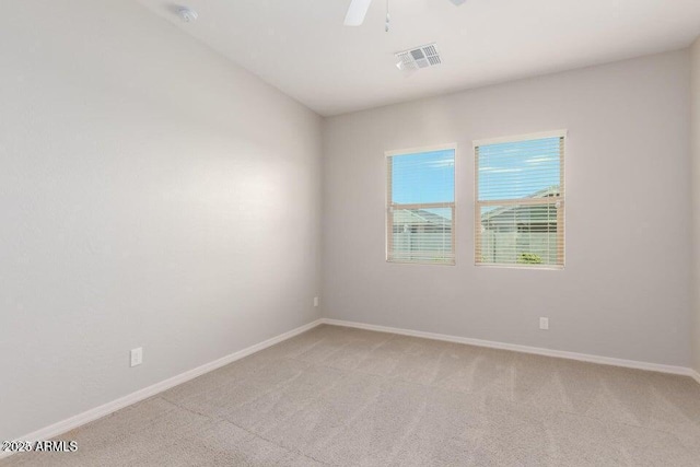 carpeted spare room featuring ceiling fan