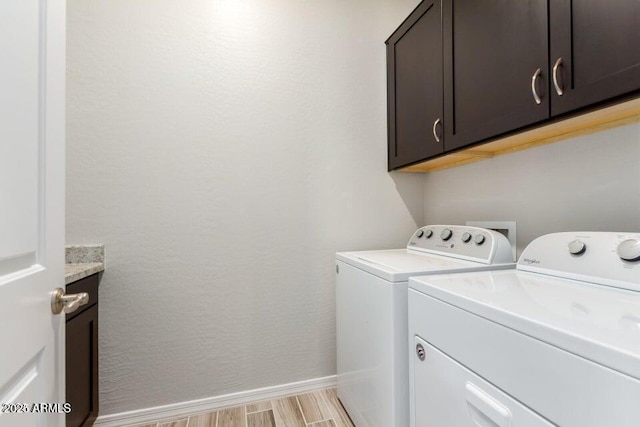 laundry area with separate washer and dryer, cabinets, and light wood-type flooring