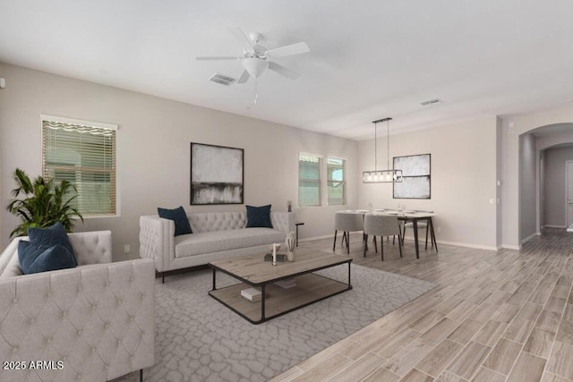 living room with ceiling fan and light wood-type flooring