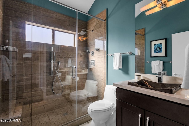 bathroom with a shower with door, toilet, vanity, and vaulted ceiling