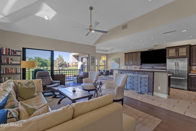 living room with ceiling fan, light hardwood / wood-style flooring, and high vaulted ceiling