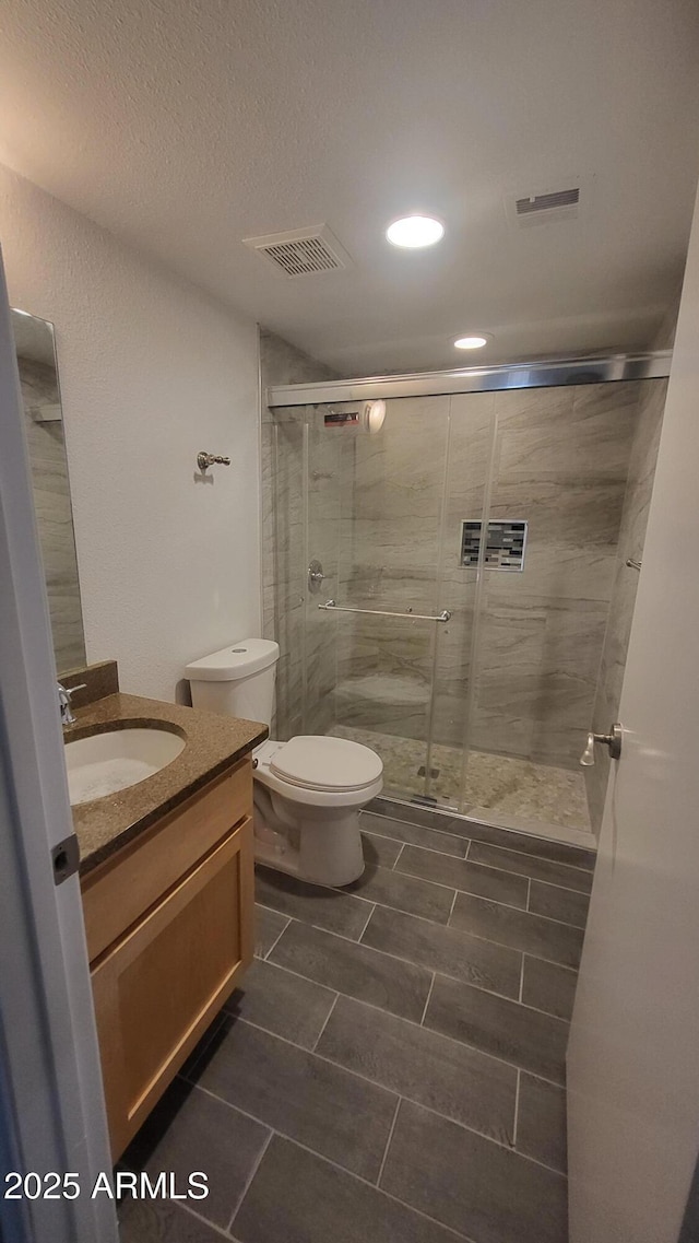 4704 E Paradise Village Pkwy N Unit 211, Phoenix, AZ 85032 - bathroom with vanity, a stall shower, toilet, tile patterned flooring, and a textured ceiling