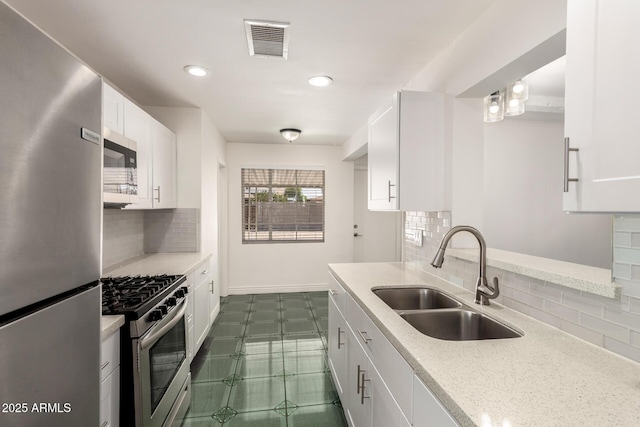 5635 N 35th Dr, Phoenix, AZ 85019 - kitchen with appliances with stainless steel finishes, a sink, tasteful backsplash, white cabinets, and recessed lighting
