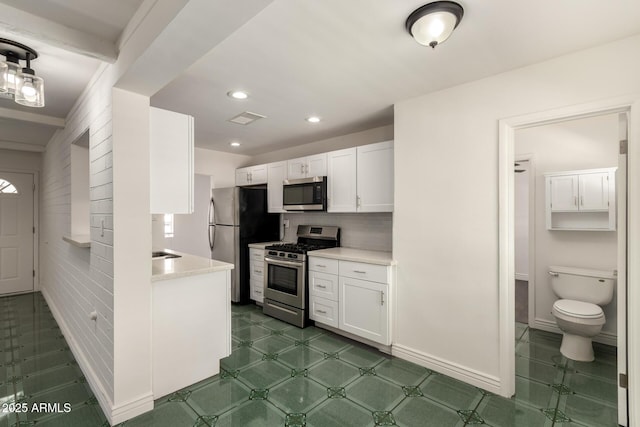 5635 N 35th Dr, Phoenix, AZ 85019 - kitchen with stainless steel appliances, white cabinets, light countertops, tasteful backsplash, and recessed lighting