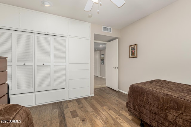 bedroom with hardwood / wood-style floors, a closet, and ceiling fan