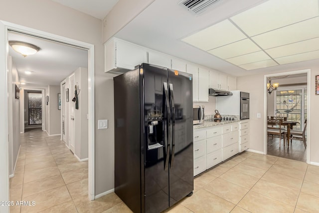 kitchen featuring white cabinets, light tile patterned floors, light stone countertops, a notable chandelier, and black appliances