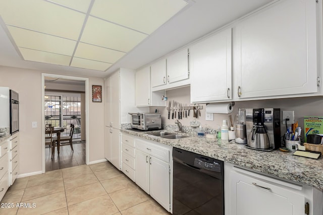 kitchen featuring black appliances, light stone countertops, white cabinetry, sink, and light tile patterned flooring