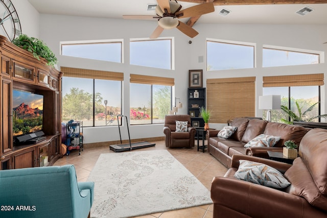 tiled living room featuring ceiling fan and high vaulted ceiling