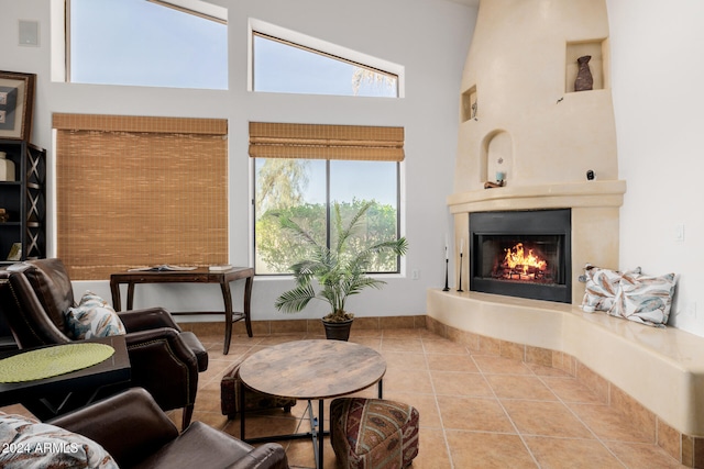 tiled living room featuring a large fireplace and high vaulted ceiling