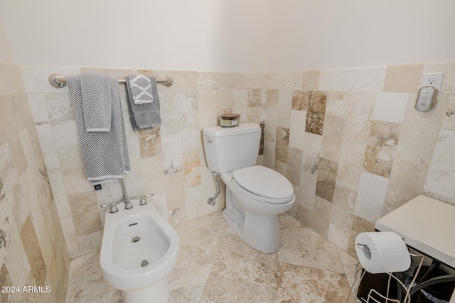 bathroom featuring tile walls, a bidet, and toilet