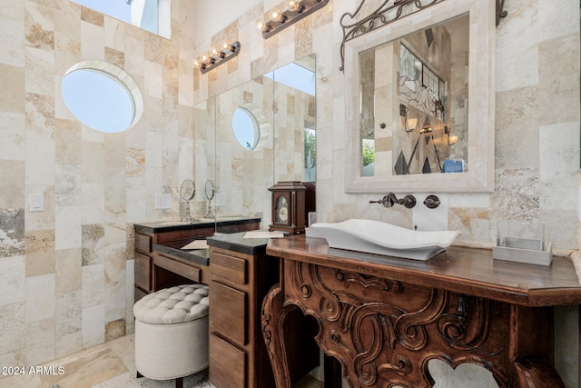 bathroom featuring vanity and tile walls