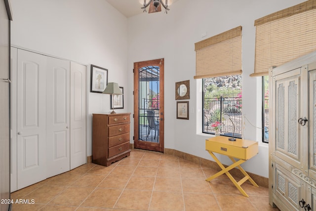 entryway featuring light tile patterned floors and a towering ceiling