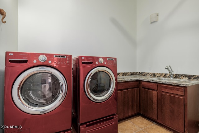 laundry area featuring cabinets, light tile patterned flooring, sink, and washer and dryer