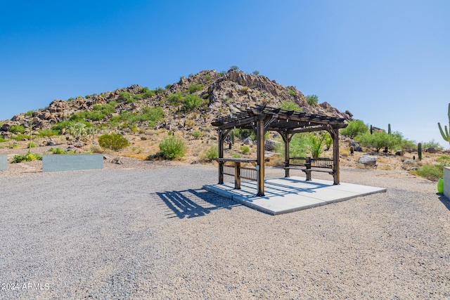 view of community with a mountain view and a pergola