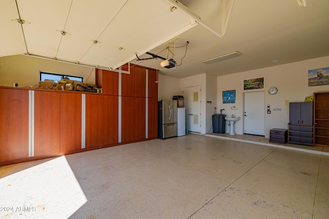 garage featuring a garage door opener and stainless steel fridge