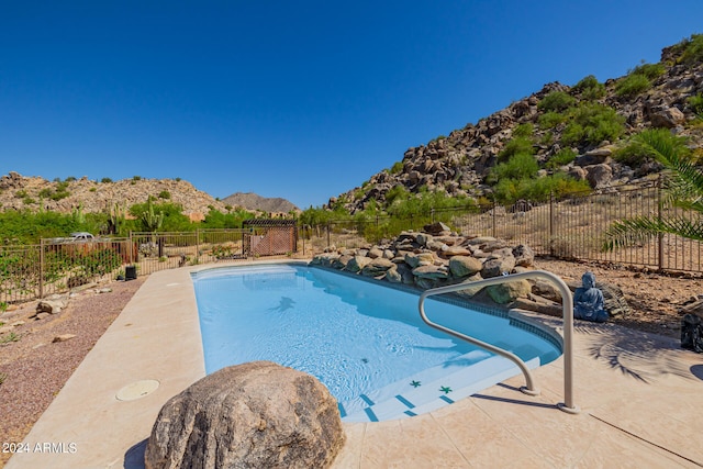 view of swimming pool with a patio area and a mountain view