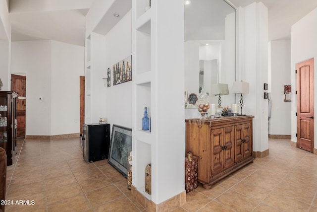 hall featuring built in features and light tile patterned flooring